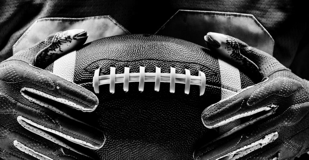 College football player holding a football.