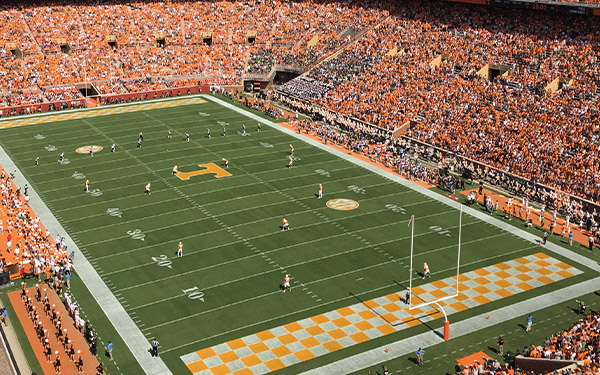 Image of a college football field with fans.
